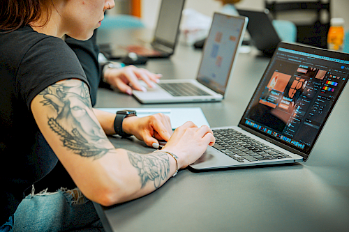 Tím s otvorenými notebookmi v zasadačke