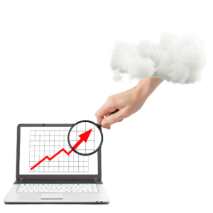 Na obrázku je ruka před počítačem. Ruka drží lupu a přibližuje rostoucí graf, který je na monitoru obrazovky.